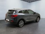 the rear end of a grey car in a white room