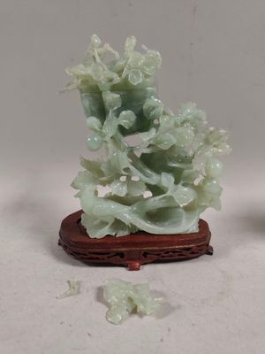une petite statue représentant des fleurs, posée sur un socle en bois