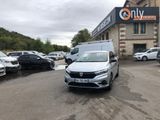 La voiture blanche est garée sur le parking situé à l'extérieur du bâtiment.