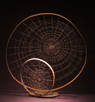 une sculpture représentant une toile d'araignée posée sur un socle en bois