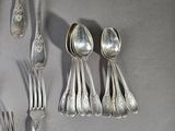 a lot of silver spoons and spoons on the table