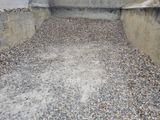 a pile of gravel on the ground next to a concrete wall