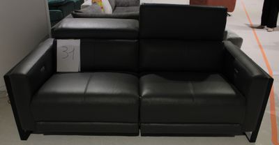 un canapé en cuir noir sur lequel est posé un ordinateur
