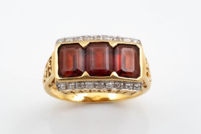 an image of a gold ring with garnets and diamonds