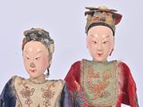 two figurines of a woman and a man standing next to each other