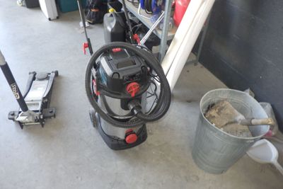 un seau de terre à côté d'une machine dans un garage