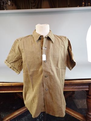 a mannequin in front of a brown shirt on a table