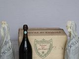 a bottle of wine and three figurines on a table