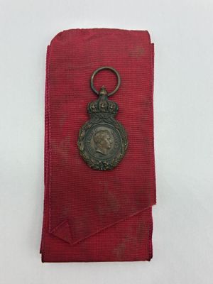 un gros plan d'un petit objet métallique posé sur un tissu rouge