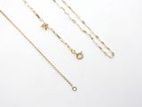 a collection of gold necklaces and bracelets on a white surface