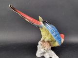 a figurine of a parrot sitting on a branch
