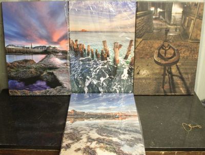 Trois toiles de tailles et de couleurs différentes sont posées sur une table