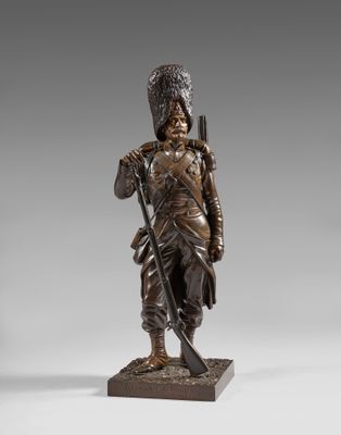 a bronze figure of a soldier with a rifle