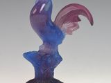 a figurine of a purple and blue fish on a black base