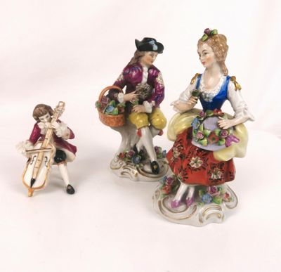 two figurines of women with baskets of flowers and a dog