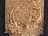 a close up of a gold plate on a black surface