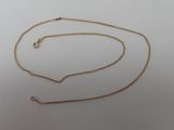 a close up of a gold chain on a white surface