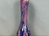 a purple and blue vase sitting on a wooden table
