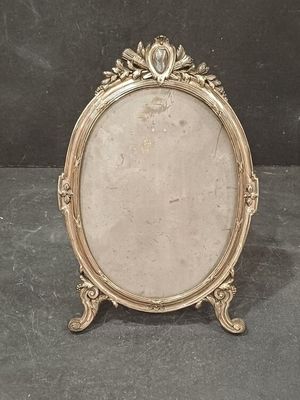 an antique silver picture frame with a decorative design on it