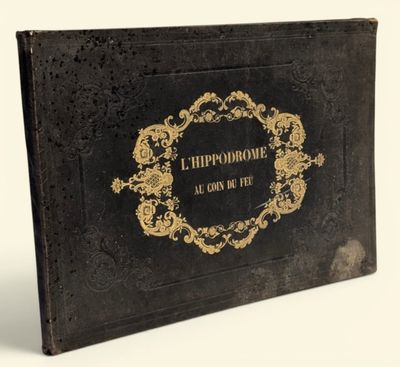 un vieux livre noir orné d'inscriptions dorées, posé sur une surface blanche