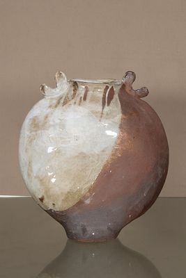 un vase marron et blanc posé sur une table en verre