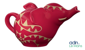 une théière en forme d'éléphant rouge ornée d'un motif doré