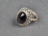 un gros plan d'une bague contenant une pierre noire