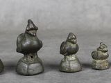 cinq figurines de tailles et de formes différentes posées sur une table