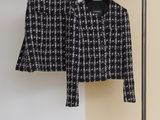 a black and white jacket and skirt hanging on a clothes rack