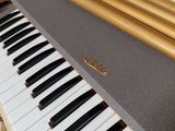 a piano that is sitting on the floor next to a chair