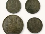 four different coins are shown in a row on a white surface