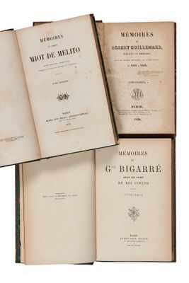 trois vieux livres posés l'un sur l'autre sur une surface blanche