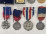 an assortment of medals and medals are displayed on a white surface