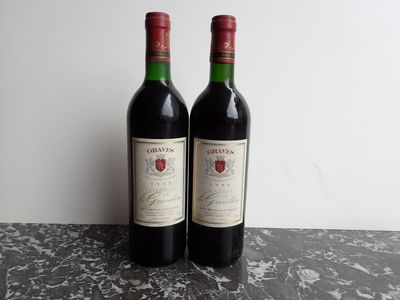 two bottles of red wine sitting on top of a marble counter top