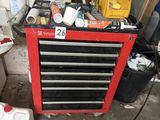 a red tool box with tools on it in a garage