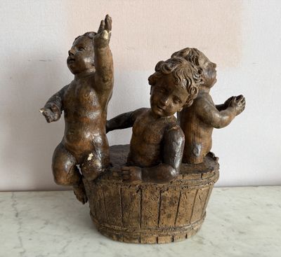 une statue représentant deux enfants assis dans un seau en bois