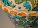 a colorful vase with flowers on it sitting on a table