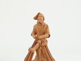 figurine of a man sitting on top of a tree stump