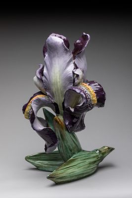 une fleur violette posée sur une feuille verte