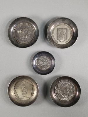 four silver coins sitting on top of a table next to each other