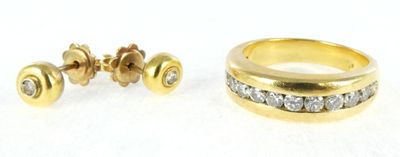 two gold rings and a pair of earrings on a white surface
