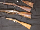 three different types of guns are lined up on a black cloth