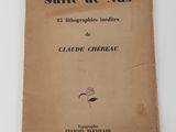 un vieux livre posé sur une table à côté d'un mur blanc