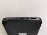the back of a black cell phone sitting on top of a white table