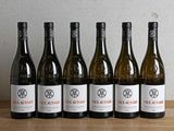 six bouteilles de vin sont alignées sur une table en bois