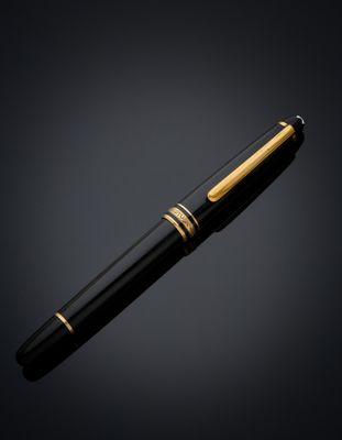 a black and gold fountain pen on a dark background