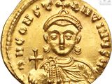 a gold coin with an image of a man holding a cross