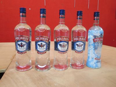 Quatre bouteilles de vodka sont alignées sur une table en bois