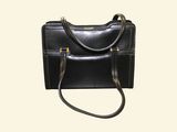 a black purse that is sitting on a white surface