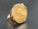 l'image d'une bague en or sur laquelle se trouve une pièce de monnaie